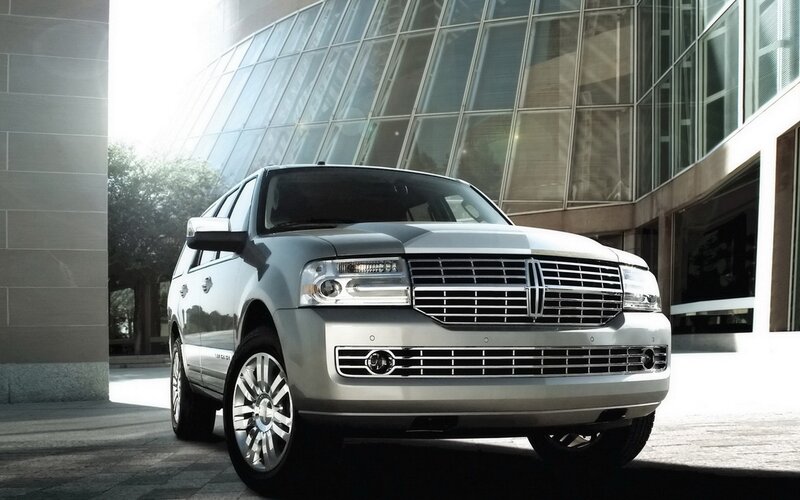 Silver Lincoln SUV in front of building