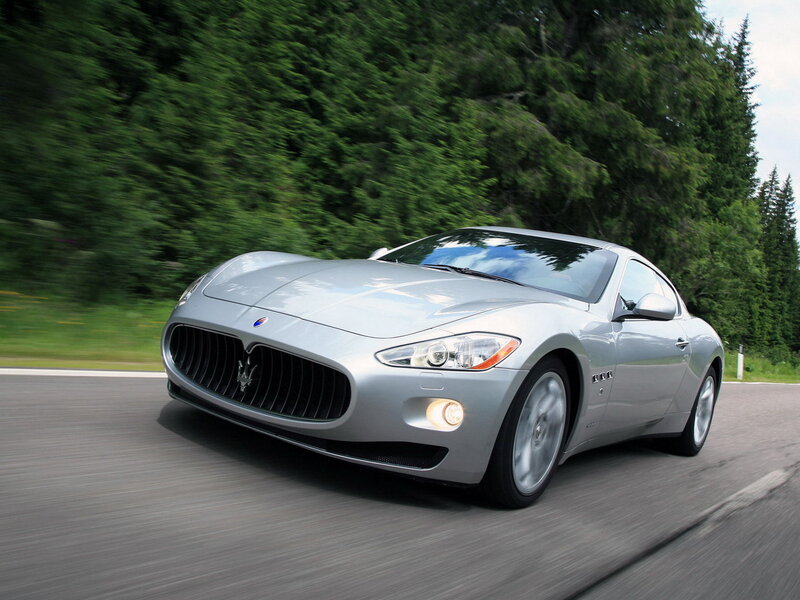 Silver Maserati driving on road
