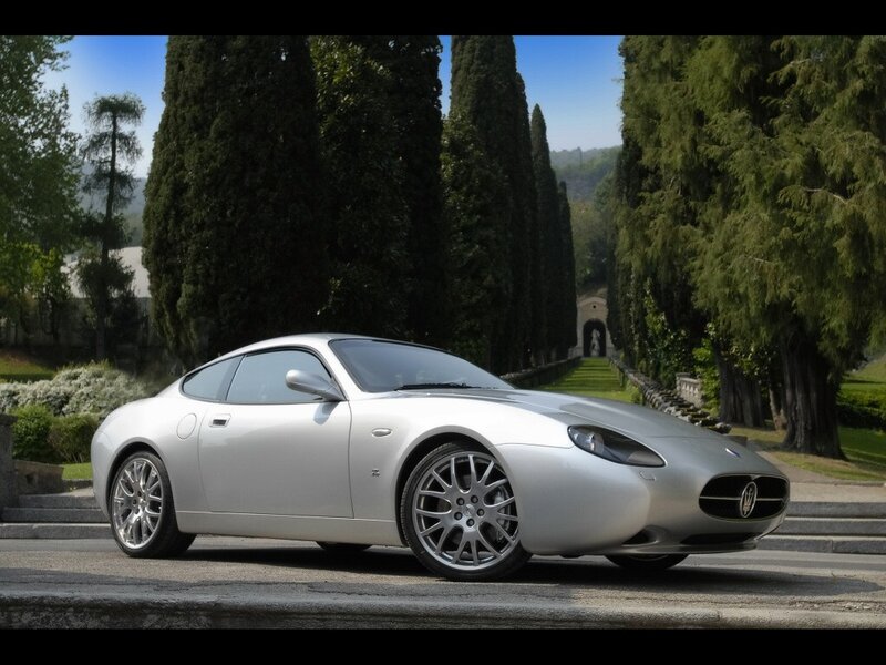 Silver Maserati on a tree-lined road