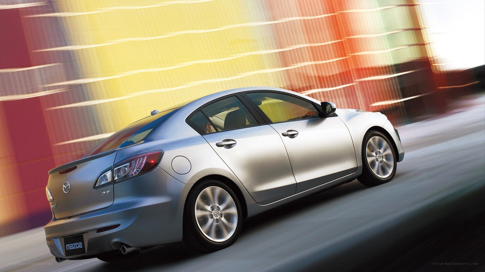 silver mazda 3 sedan in motion