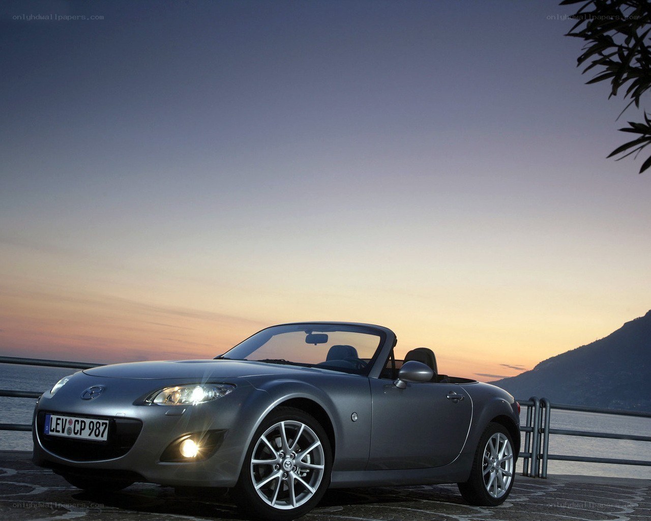 Silver Mazda Miata at sunset