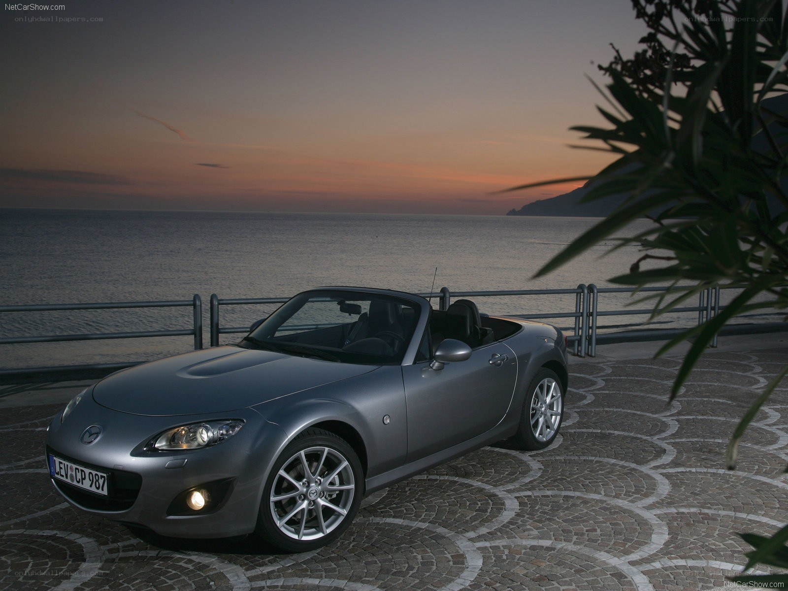Silver Mazda MX-5 at sunset