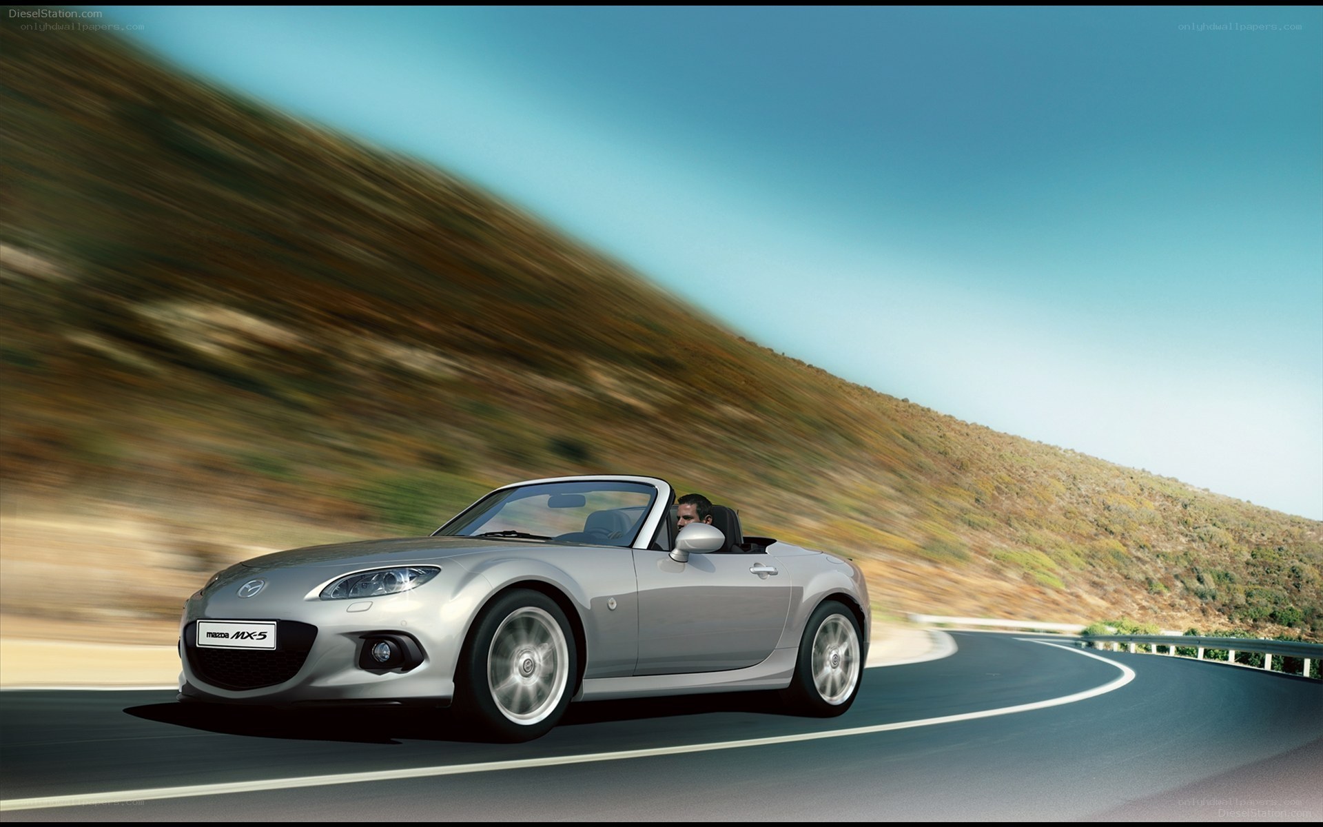 Silver Mazda MX-5 driving on a road