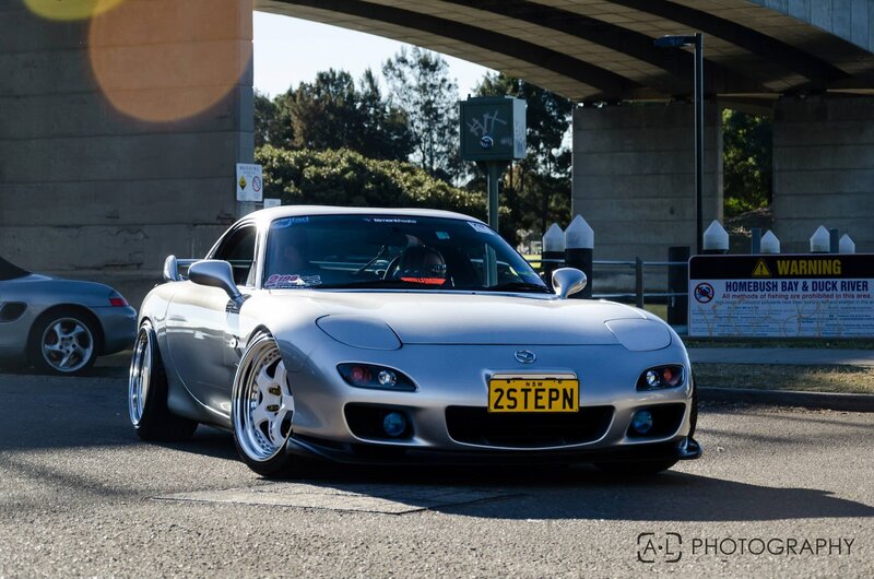 Silver Mazda RX-7 under a bridge