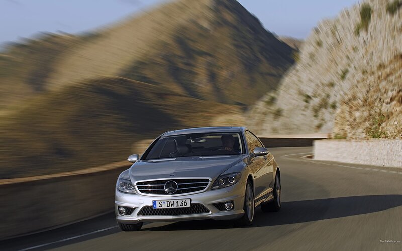 silver mercedes driving on mountain road