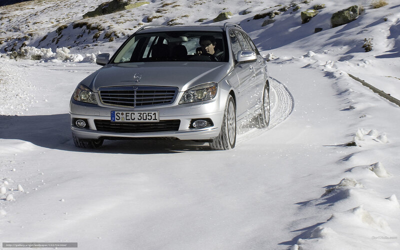 Silver Mercedes driving on snowy road