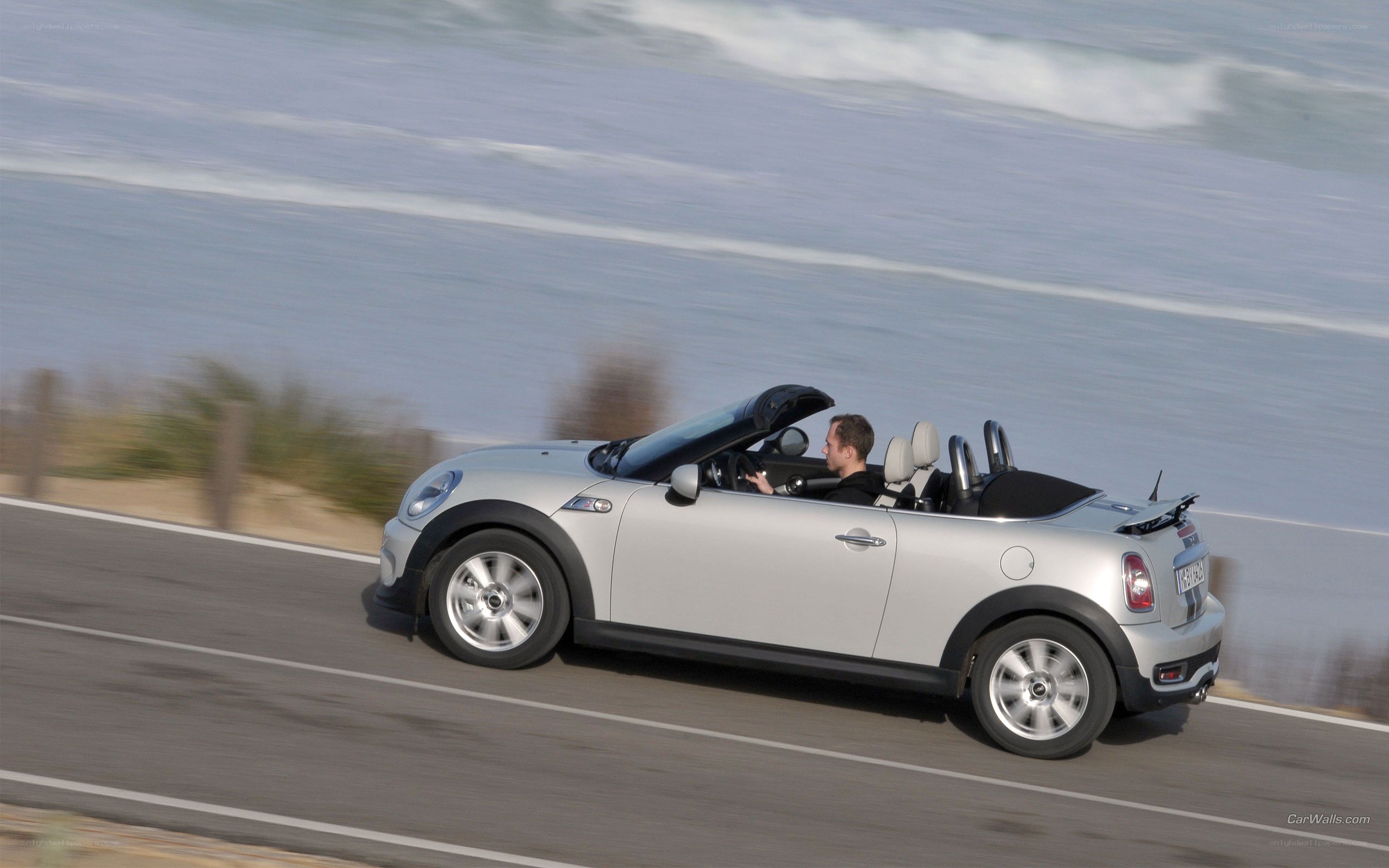 silver mini cooper driving on coast