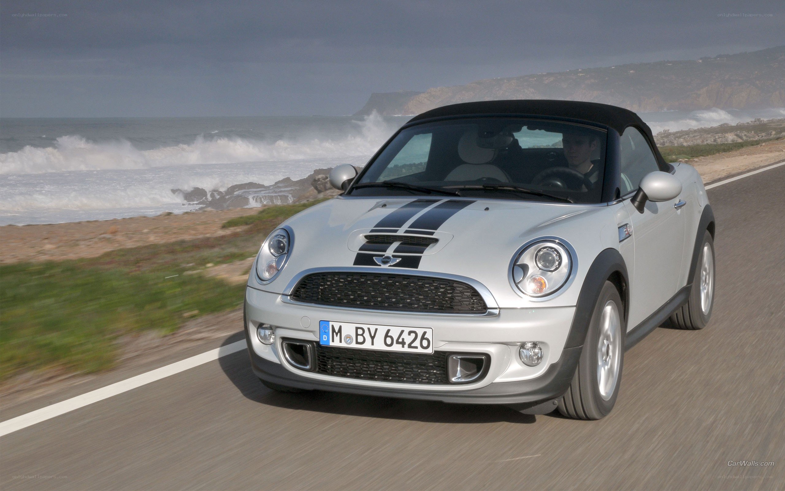 silver mini cooper driving on coast