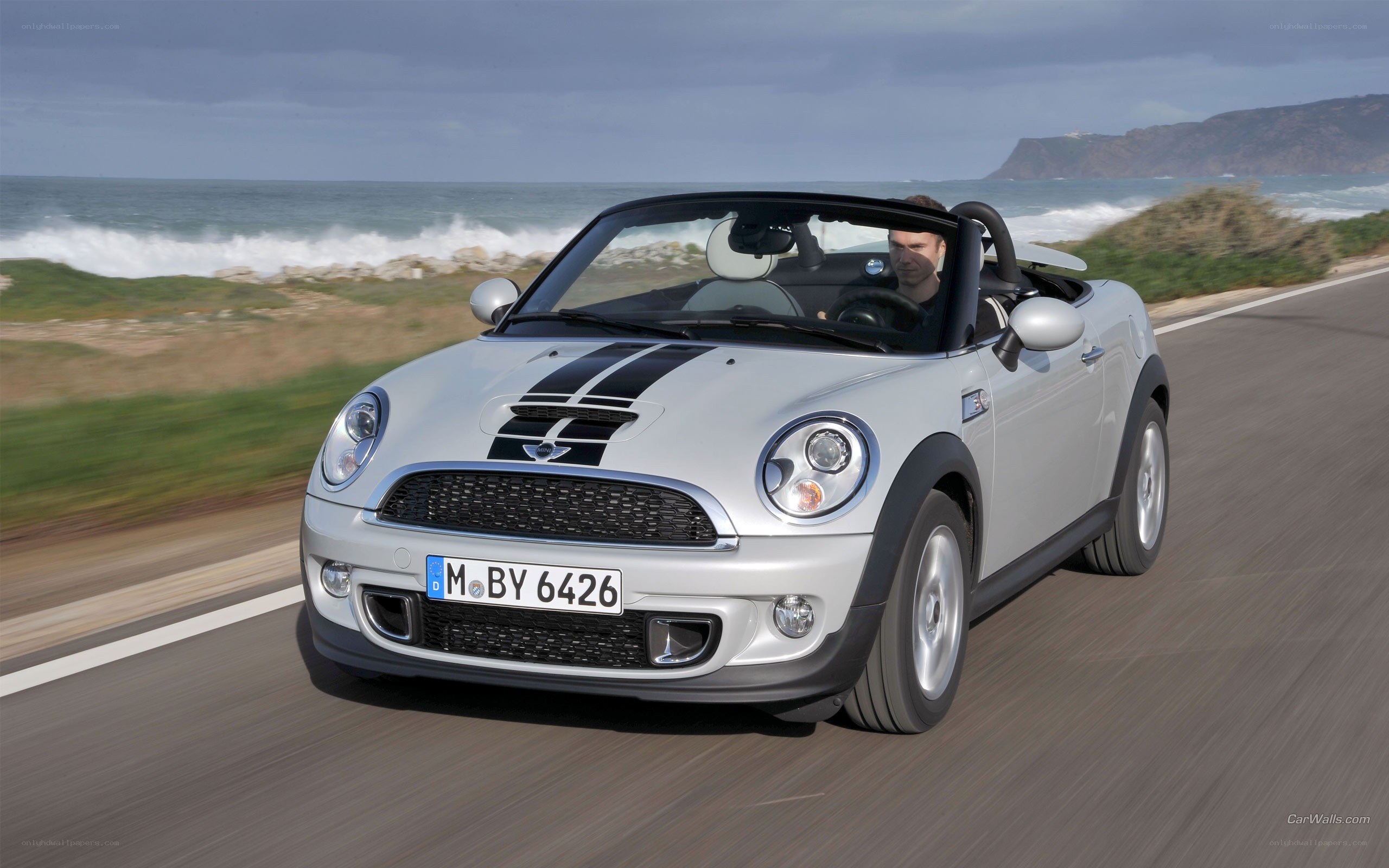 Silver MINI Cooper driving on coastal road