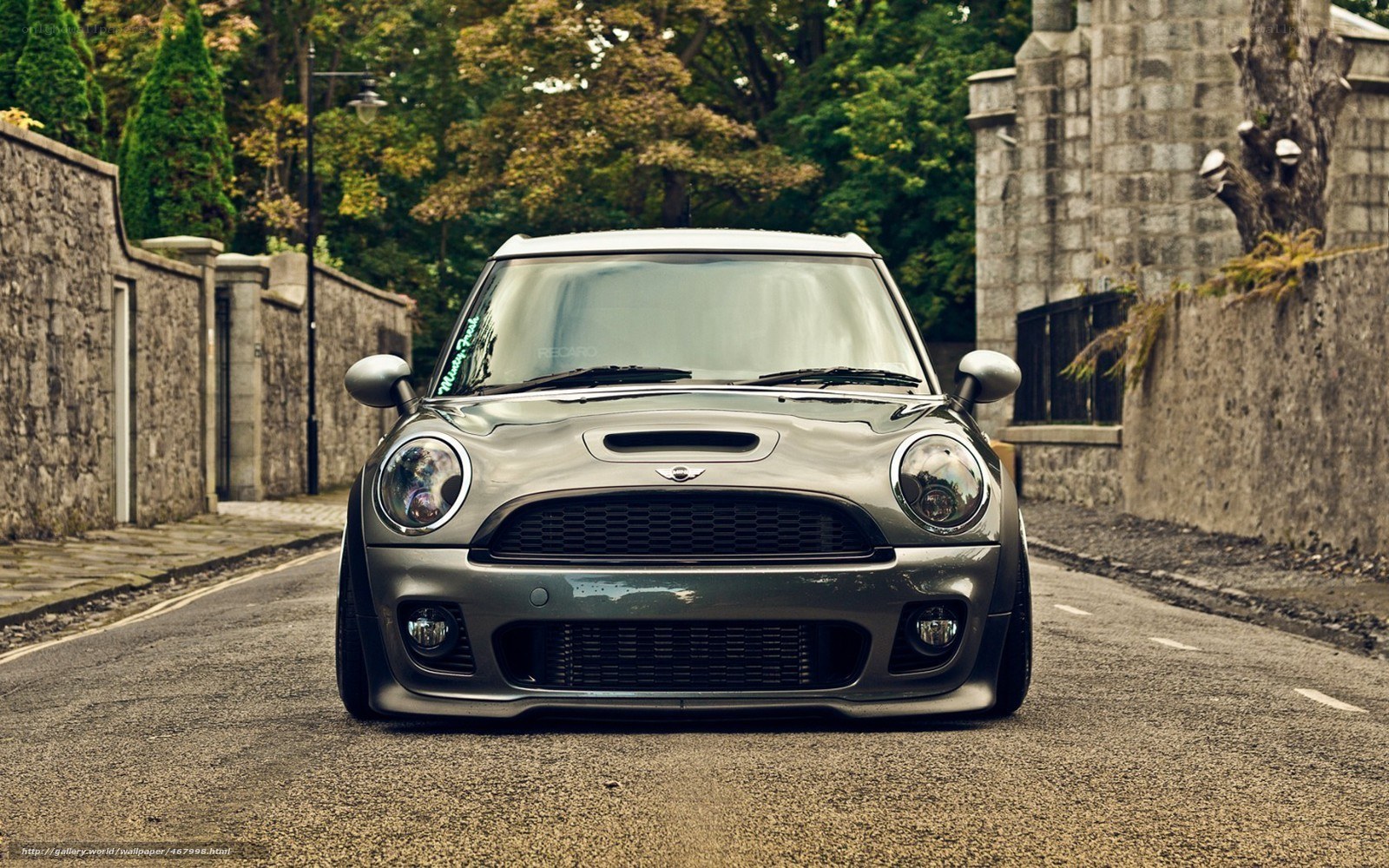 silver mini cooper on a narrow street