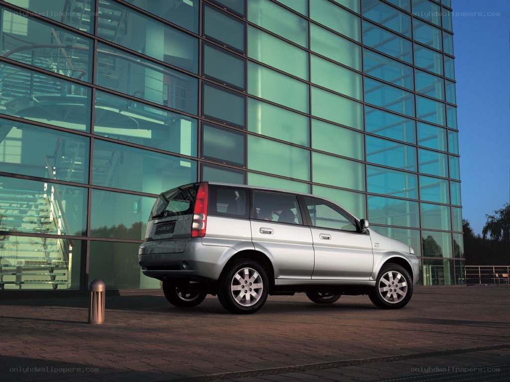 Silver minivan parked outside modern building