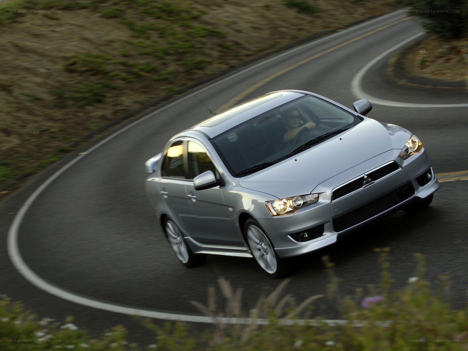 silver mitsubishi driving on road