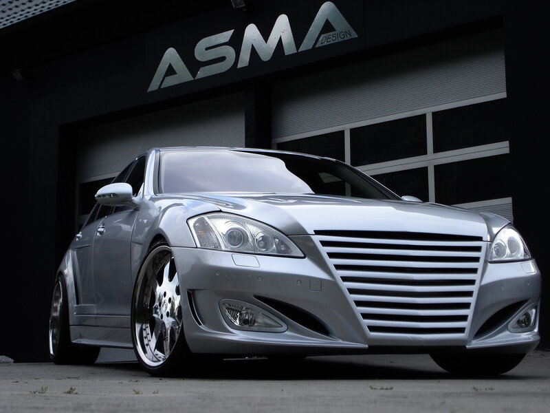 Silver modified sedan in front of garage