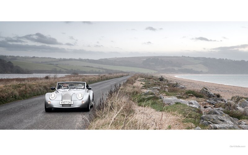 Silver Morgan car on coastal road