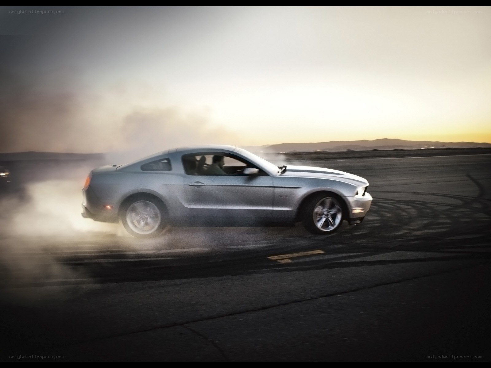 silver mustang drifting at dusk