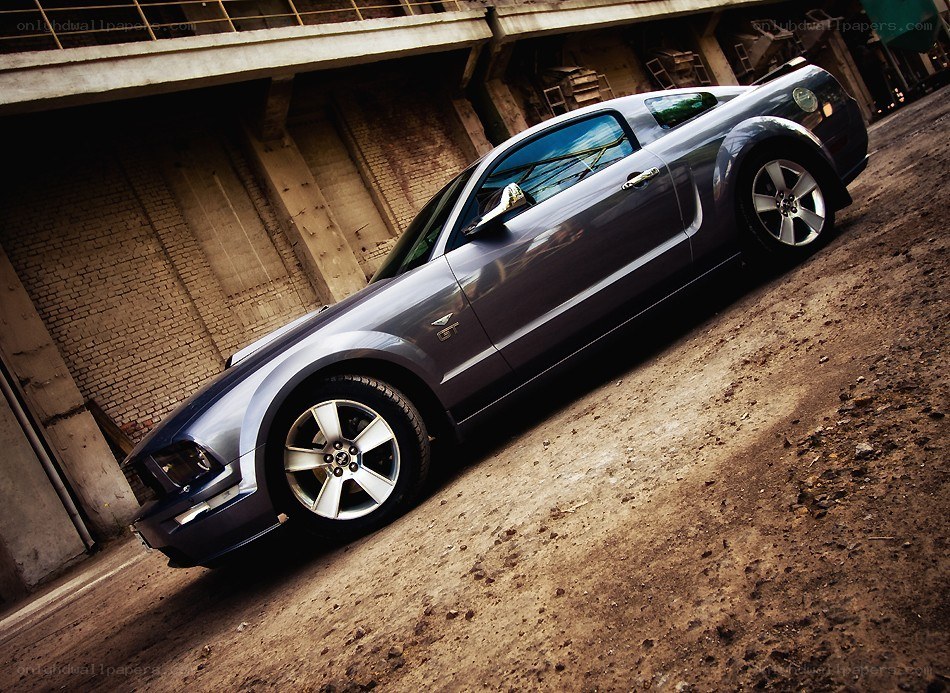 silver mustang in industrial setting