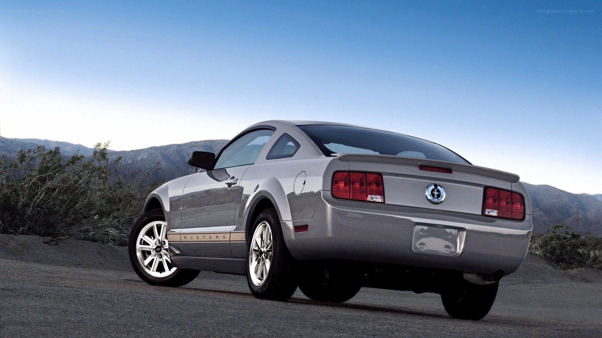 silver mustang on desert road