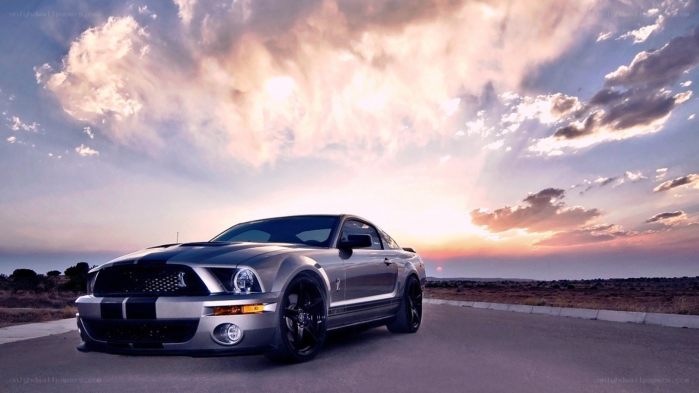 silver mustang on road at sunset