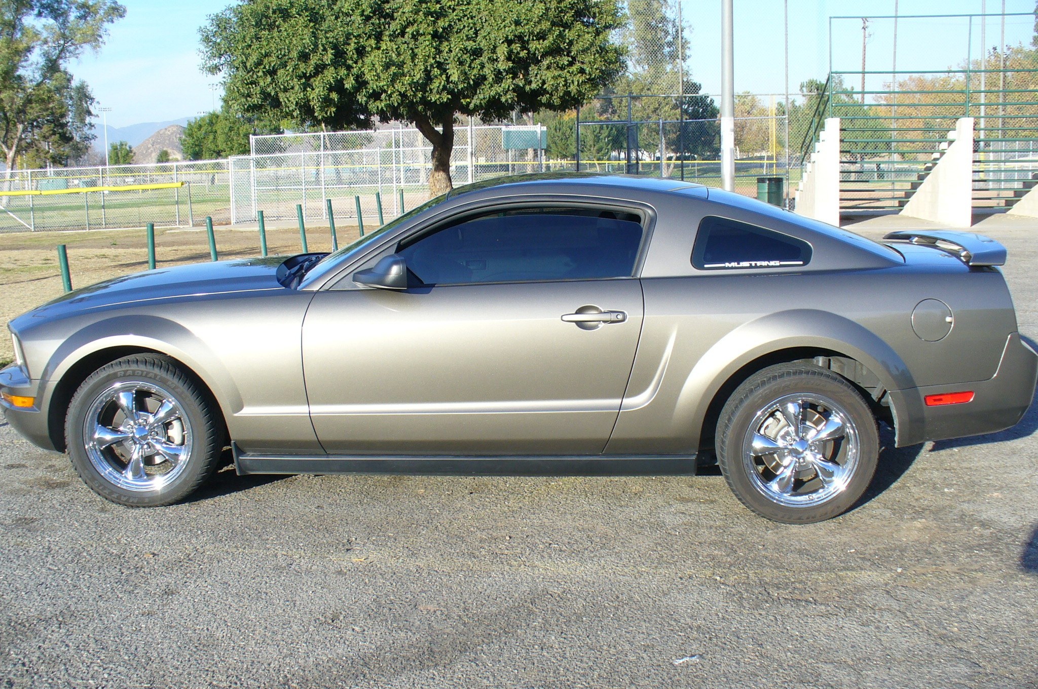 silver mustang parked at baseball field