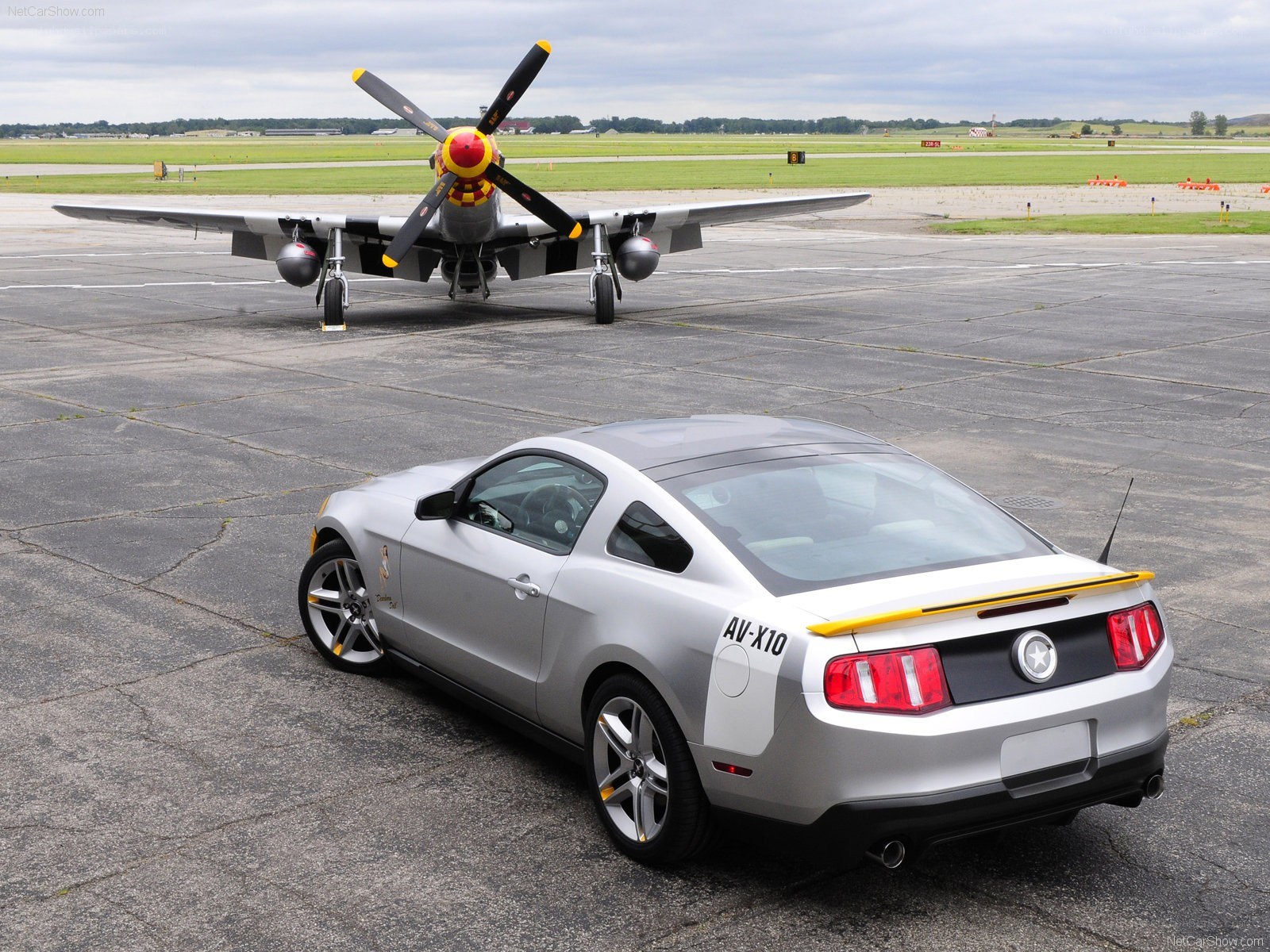Silver Mustang with vintage plane