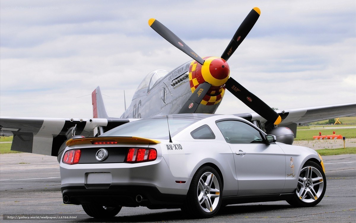 Silver Mustang with vintage plane
