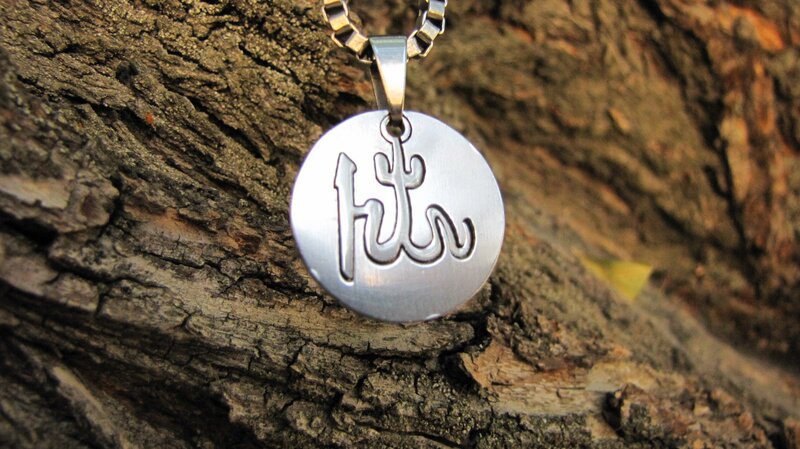 silver pendant with Arabic script