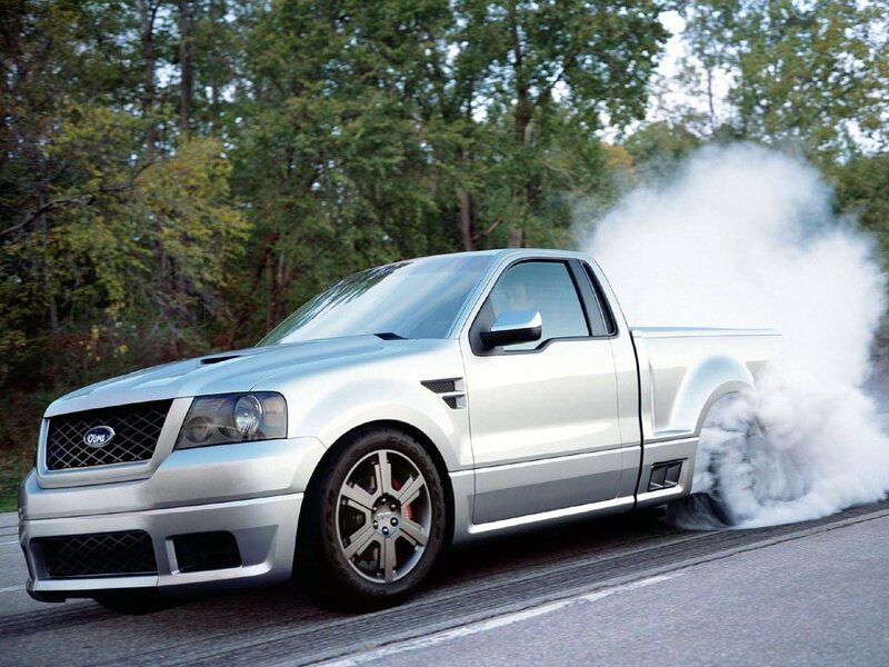 silver pickup truck doing burnout
