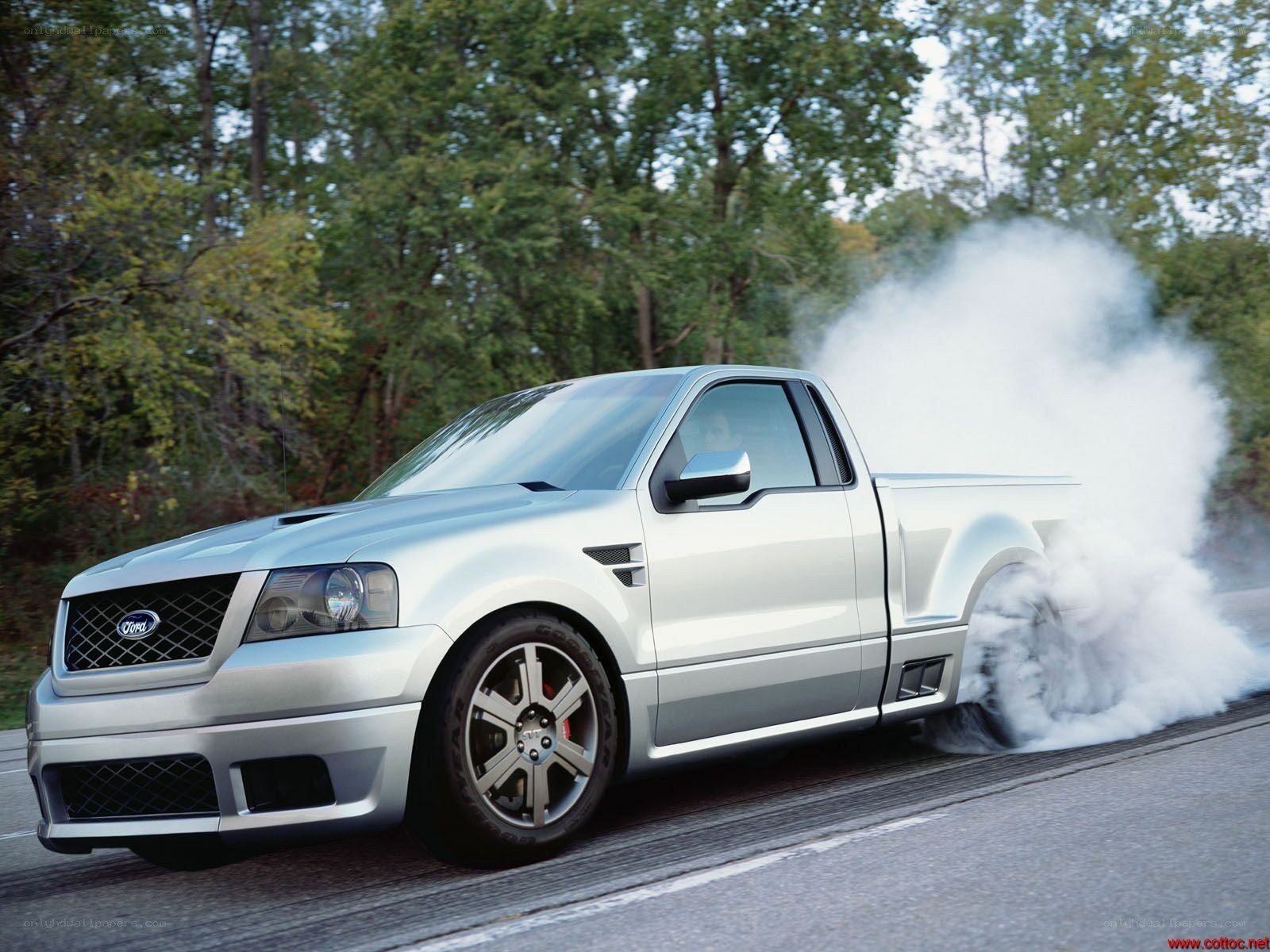 silver pickup truck doing burnout