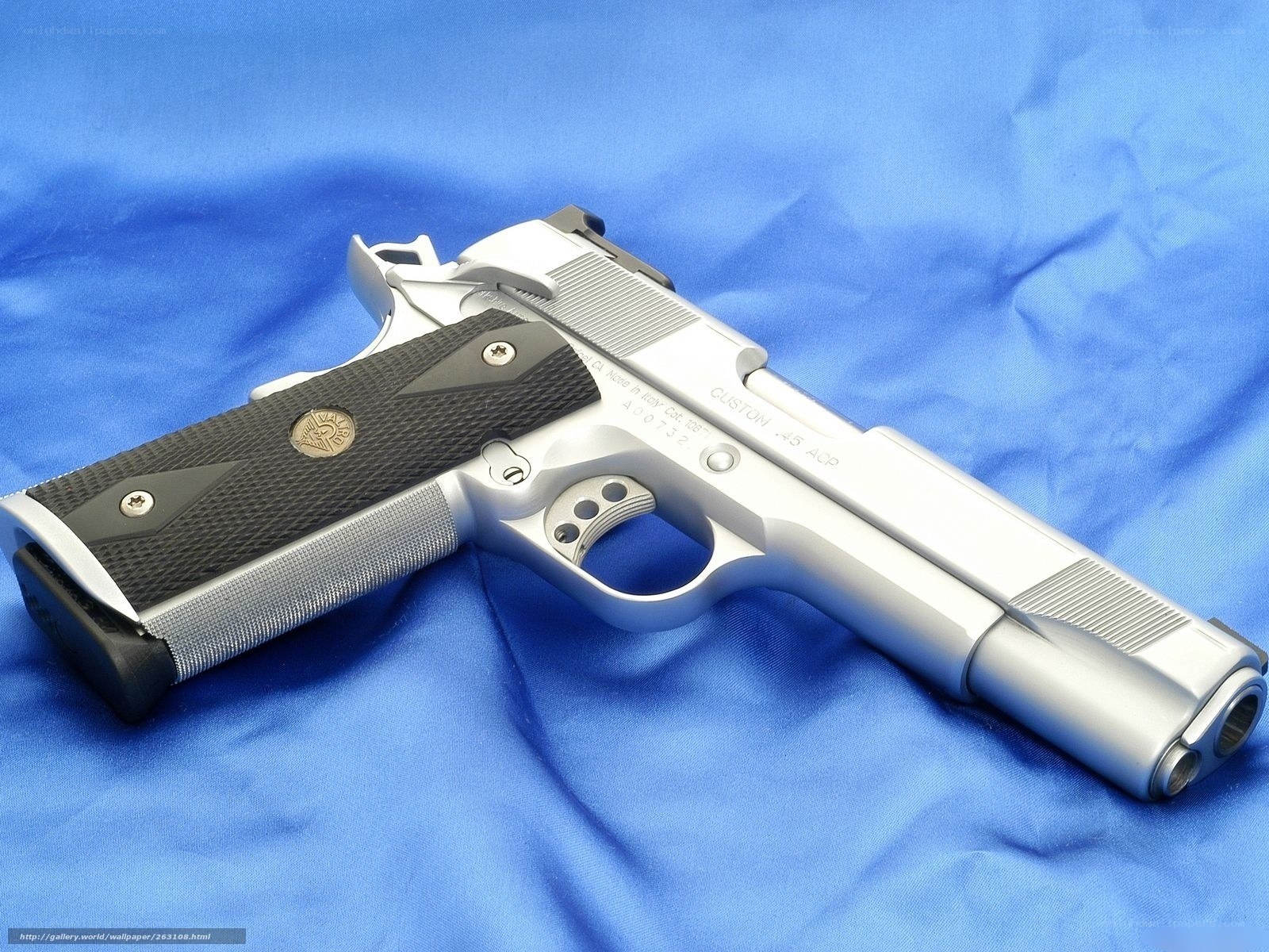 silver pistol on blue cloth