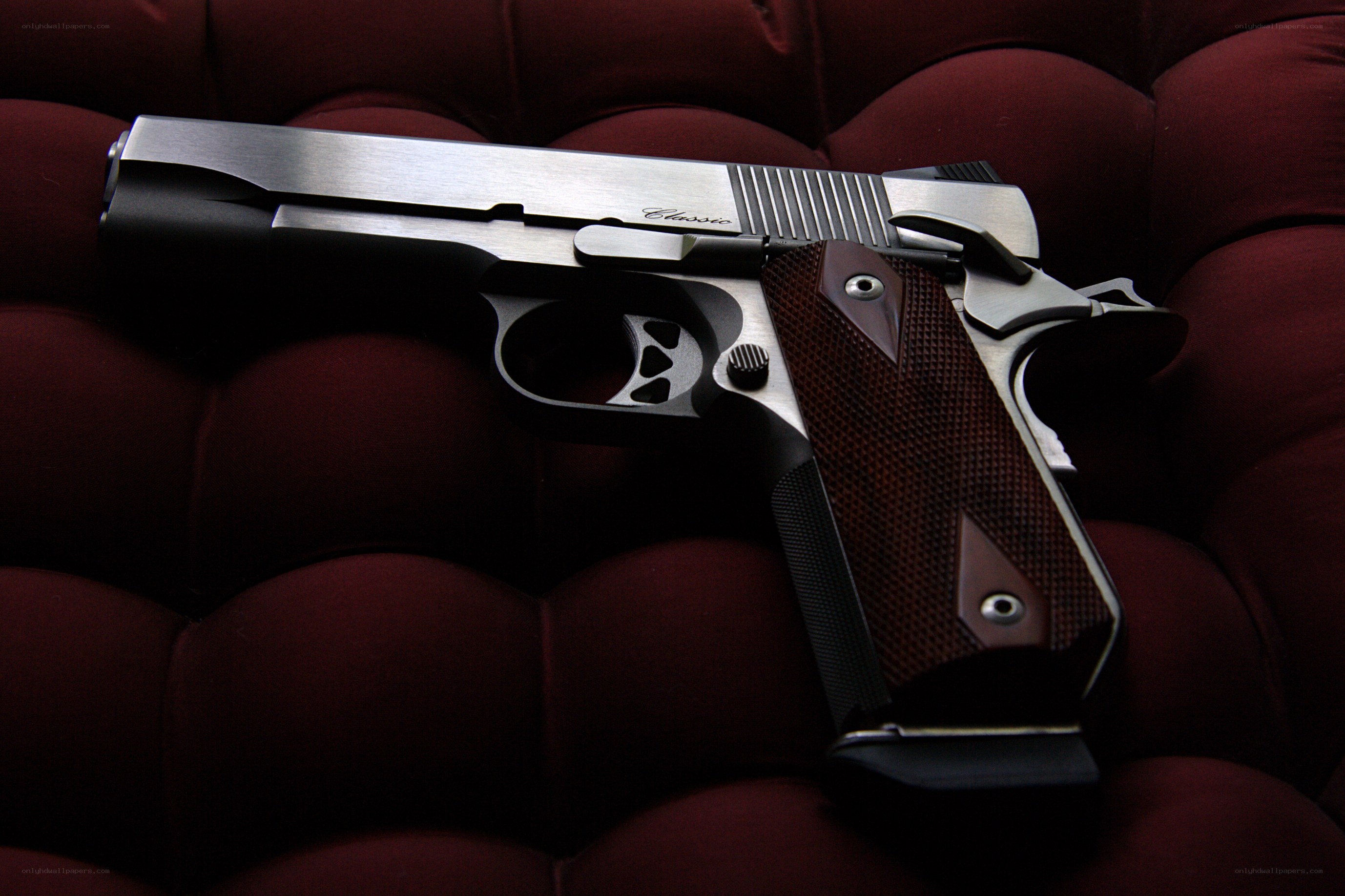 silver pistol on red couch