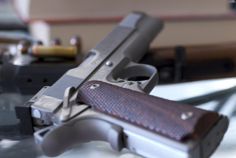 silver pistol with wooden grip