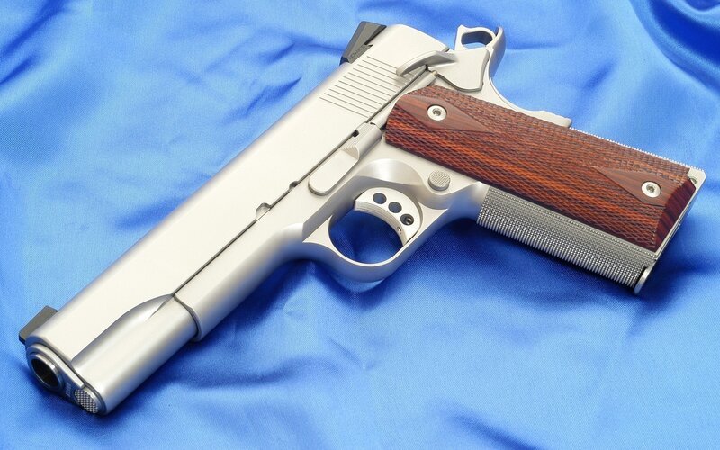 silver pistol with wooden grips