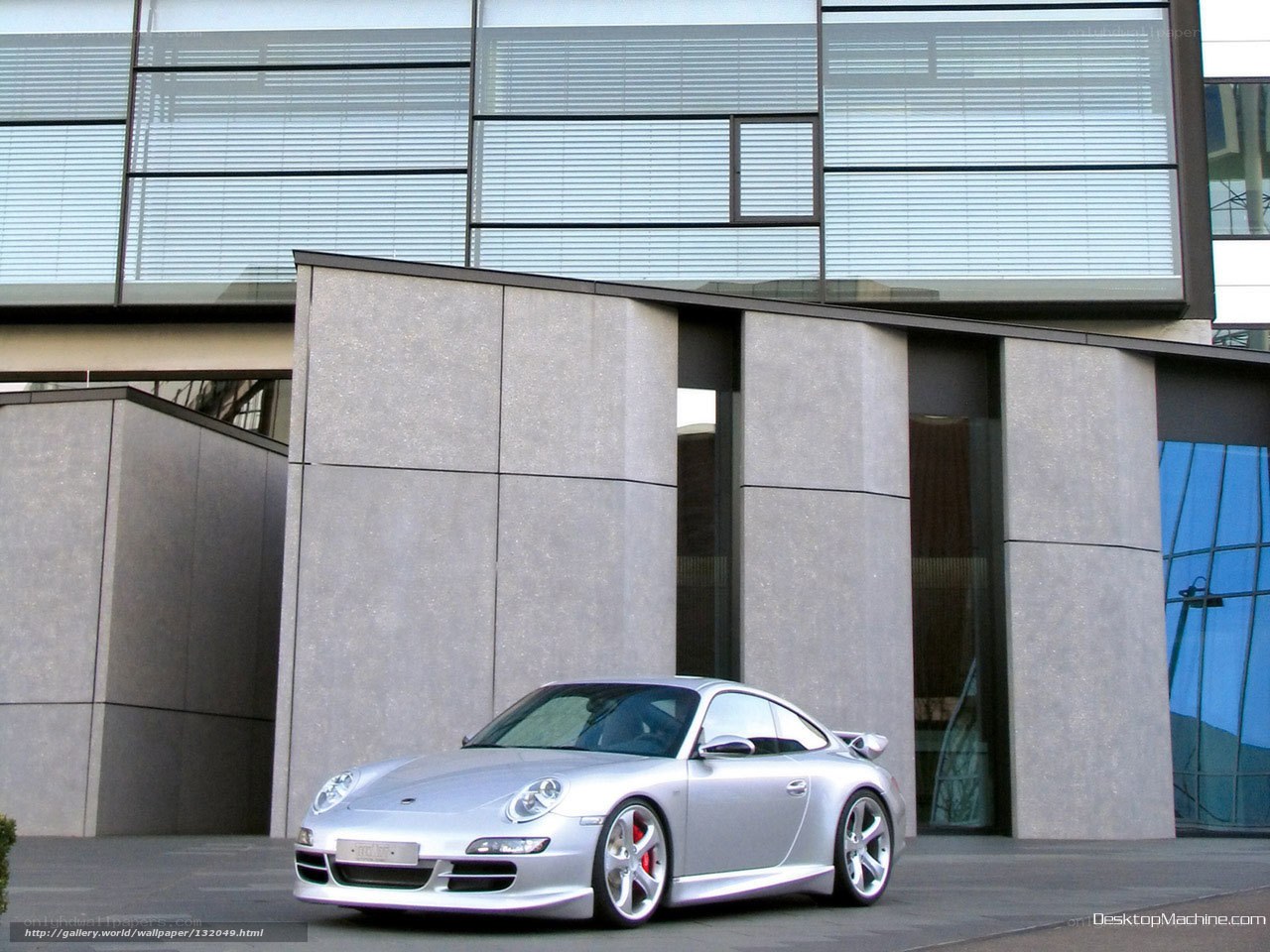 Silver Porsche 911 in front of modern building
