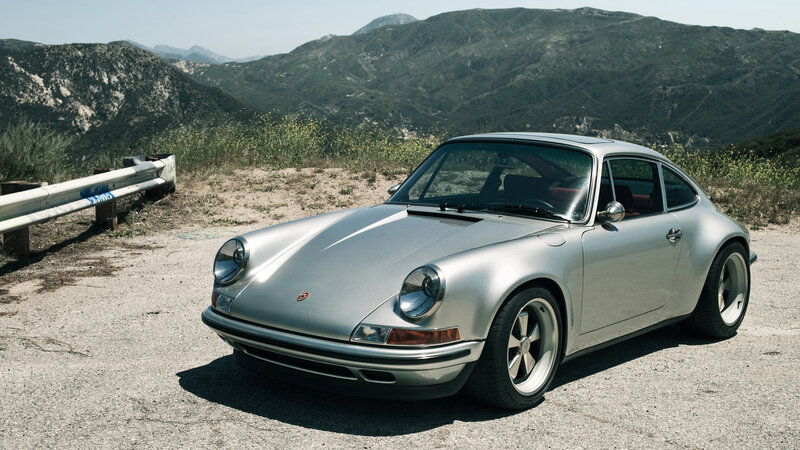 Silver Porsche 911 on a mountain road