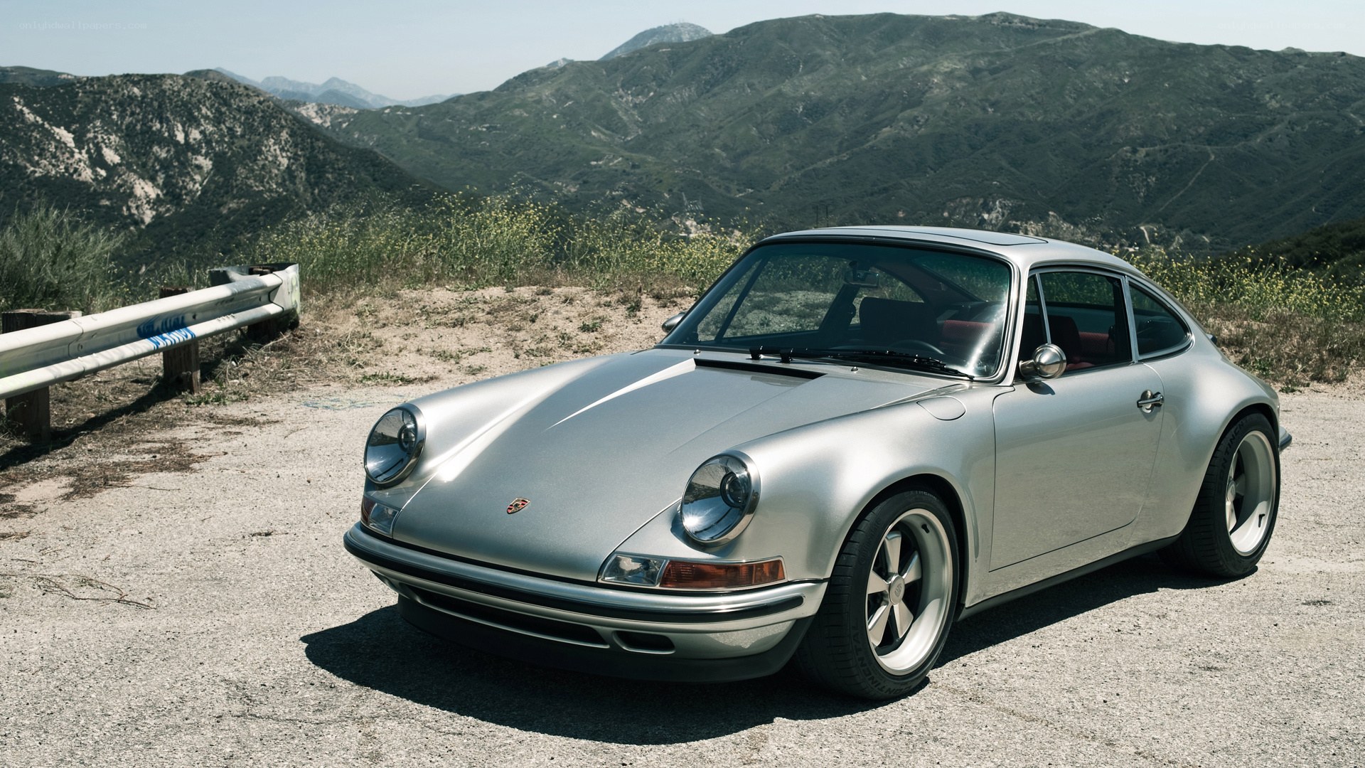 Silver Porsche 911 on a mountain road
