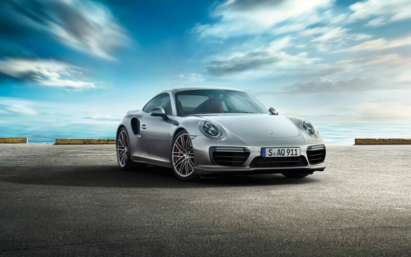 Silver Porsche 911 Turbo parked by sea