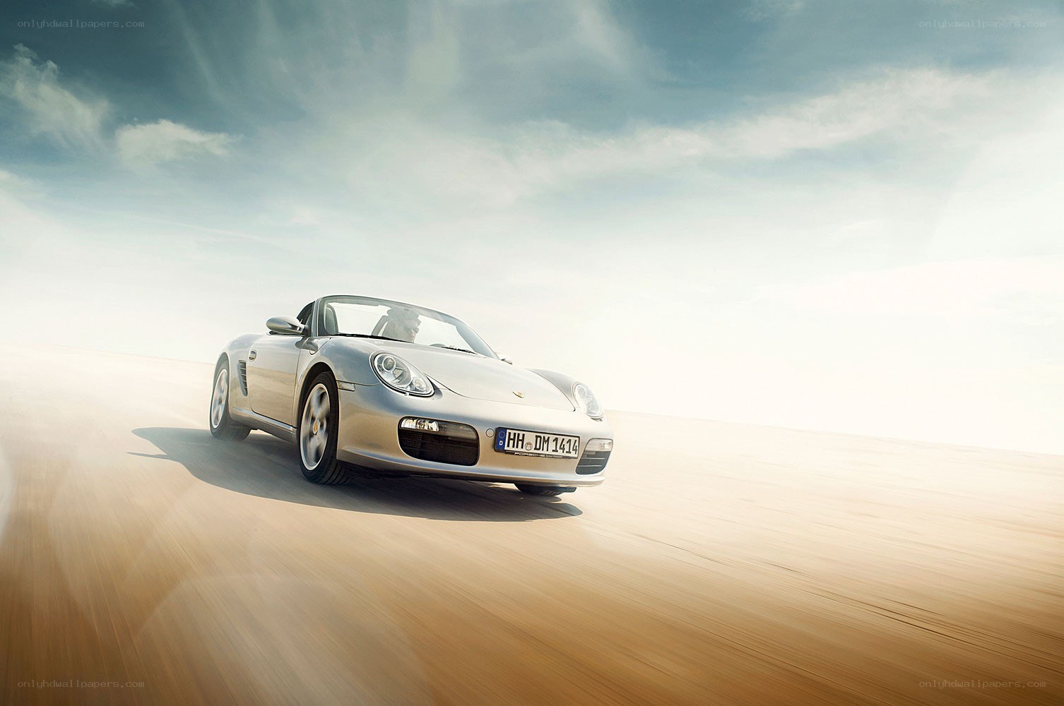 Silver Porsche convertible in motion