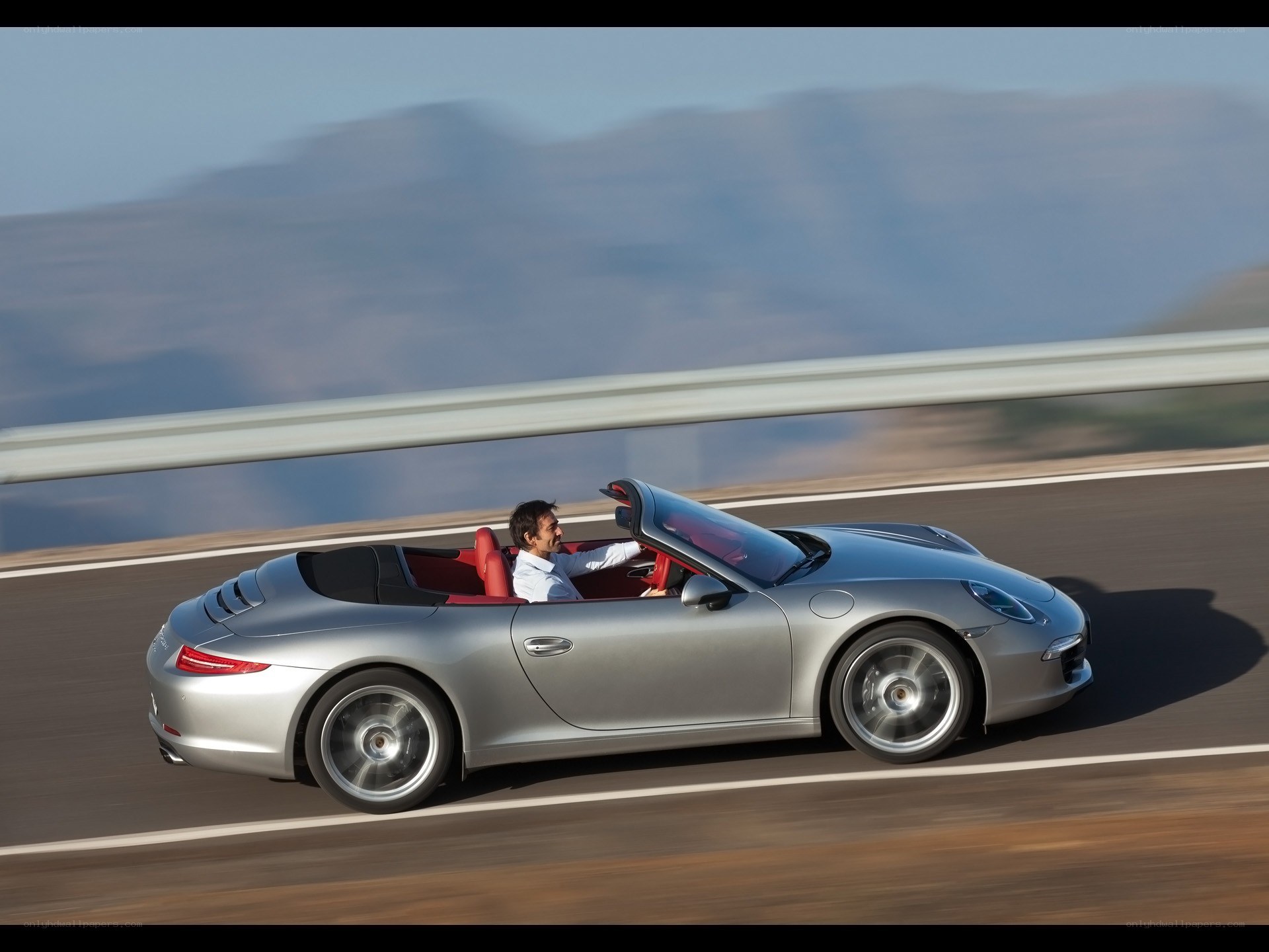 Silver Porsche convertible on road