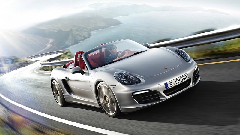 Silver Porsche driving on coastal road