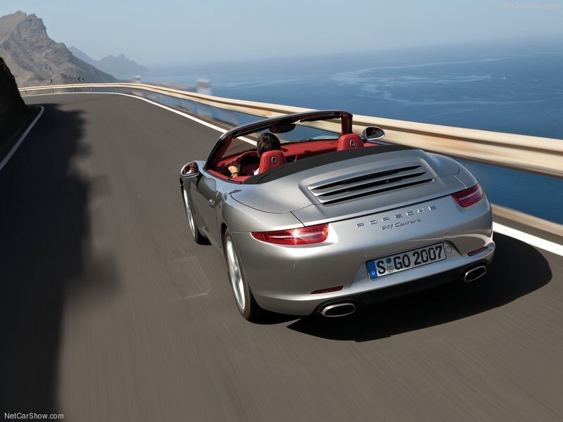 Silver Porsche driving on coastal road
