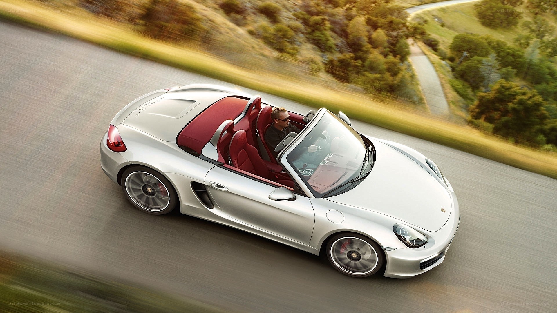 Silver Porsche driving on road