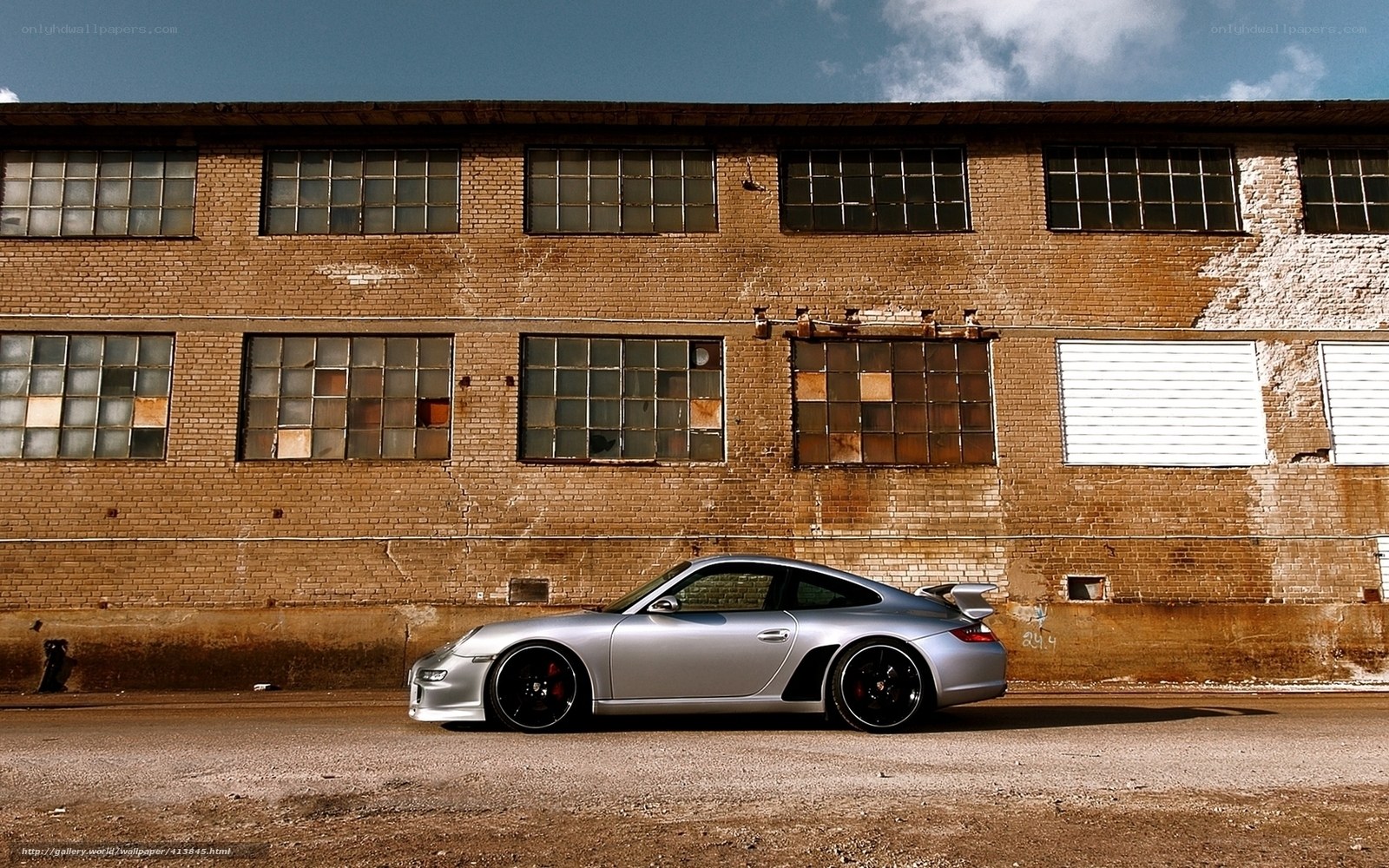 Silver Porsche in front of brick building