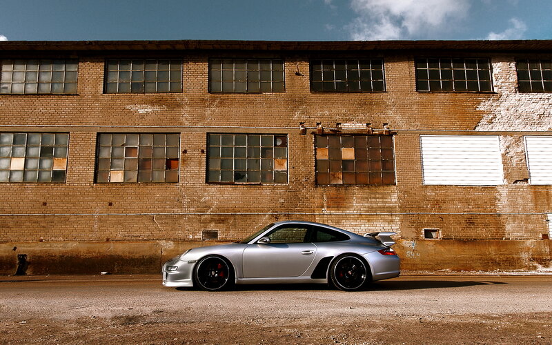 Silver Porsche in front of brick building