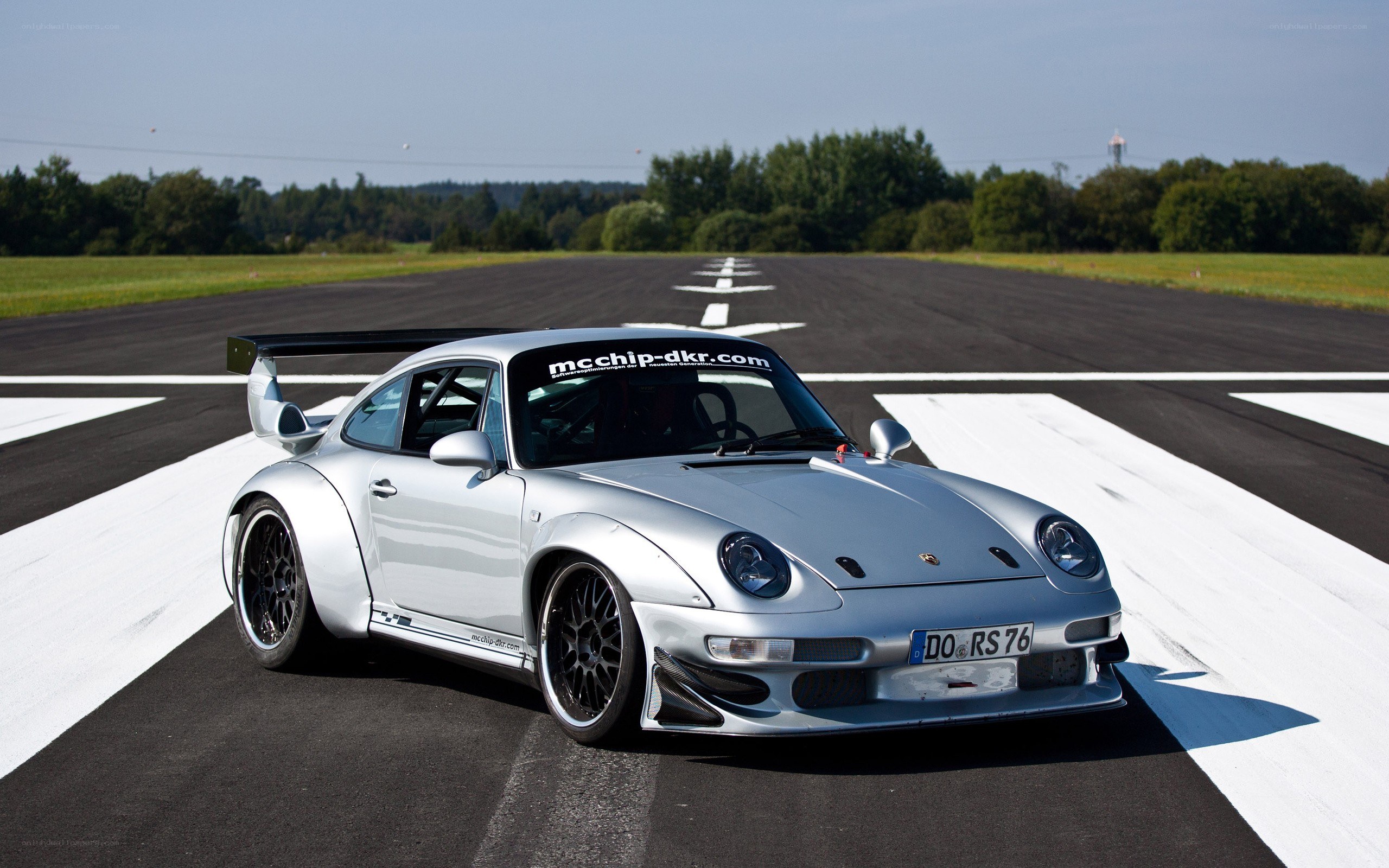 Silver Porsche on a racetrack