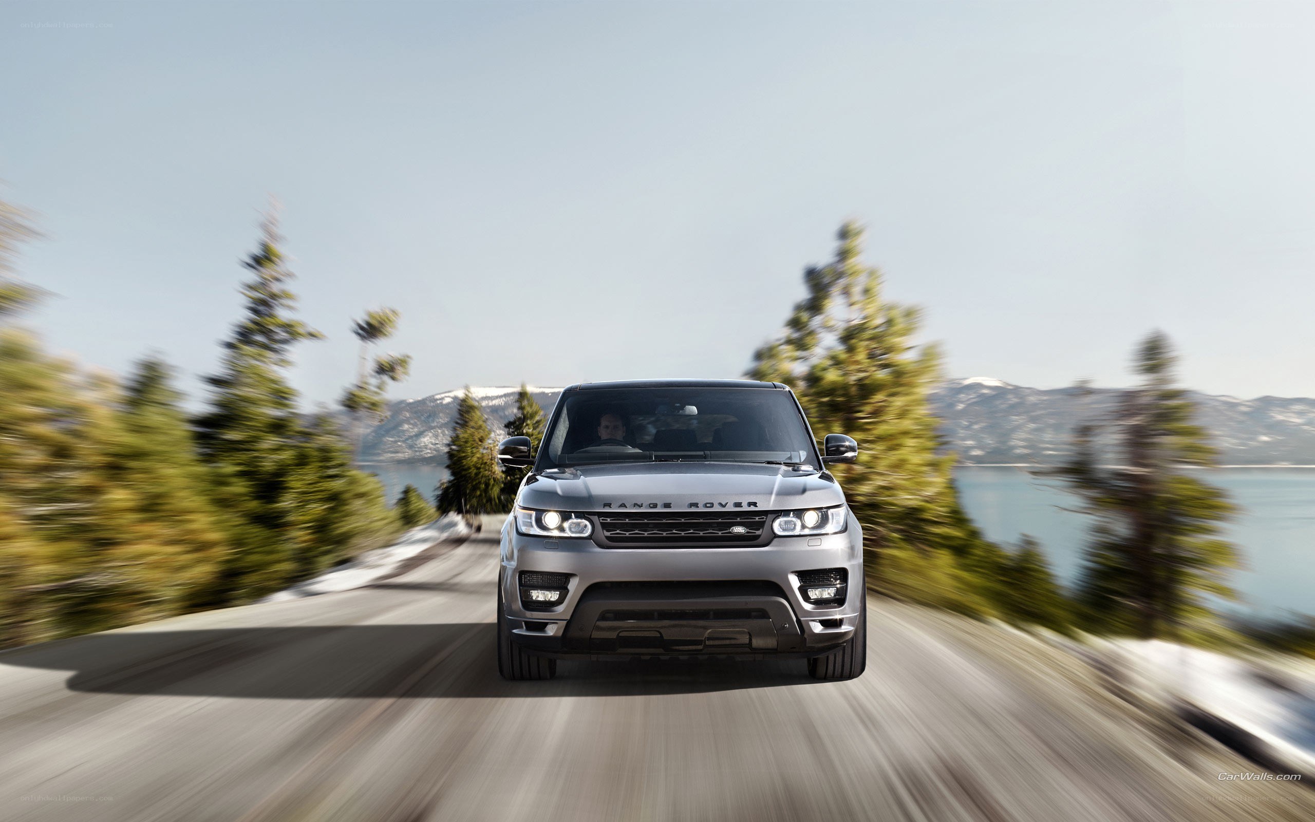 Silver Range Rover driving on a scenic road