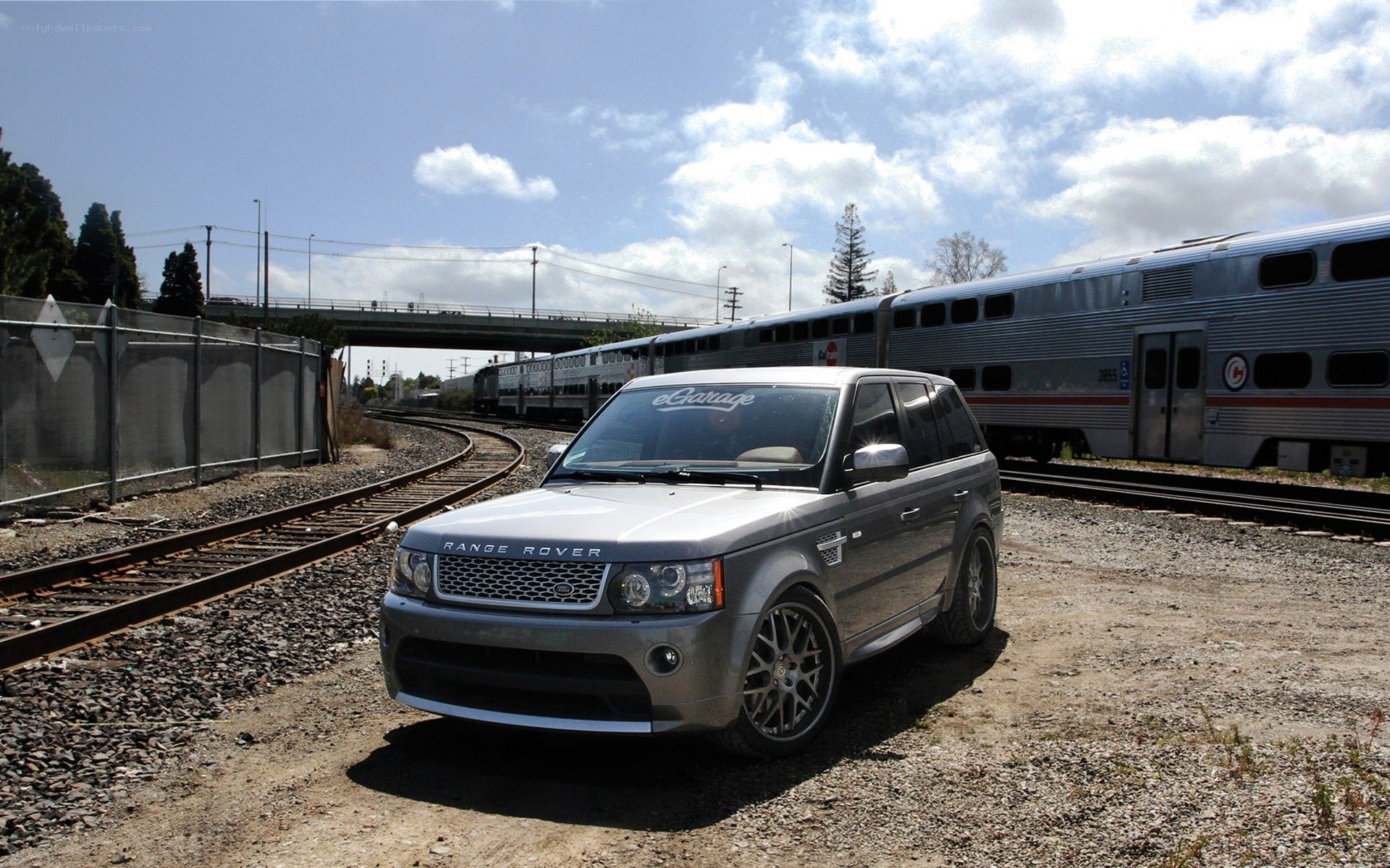 Silver Range Rover near train tracks
