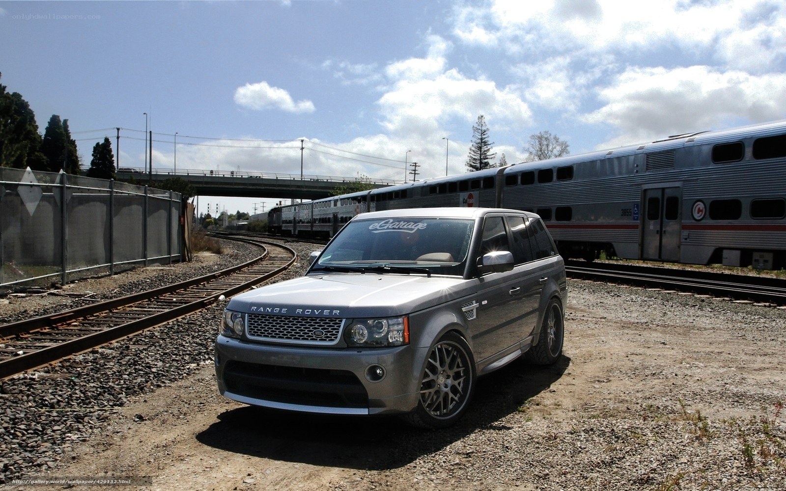 Silver Range Rover near train tracks