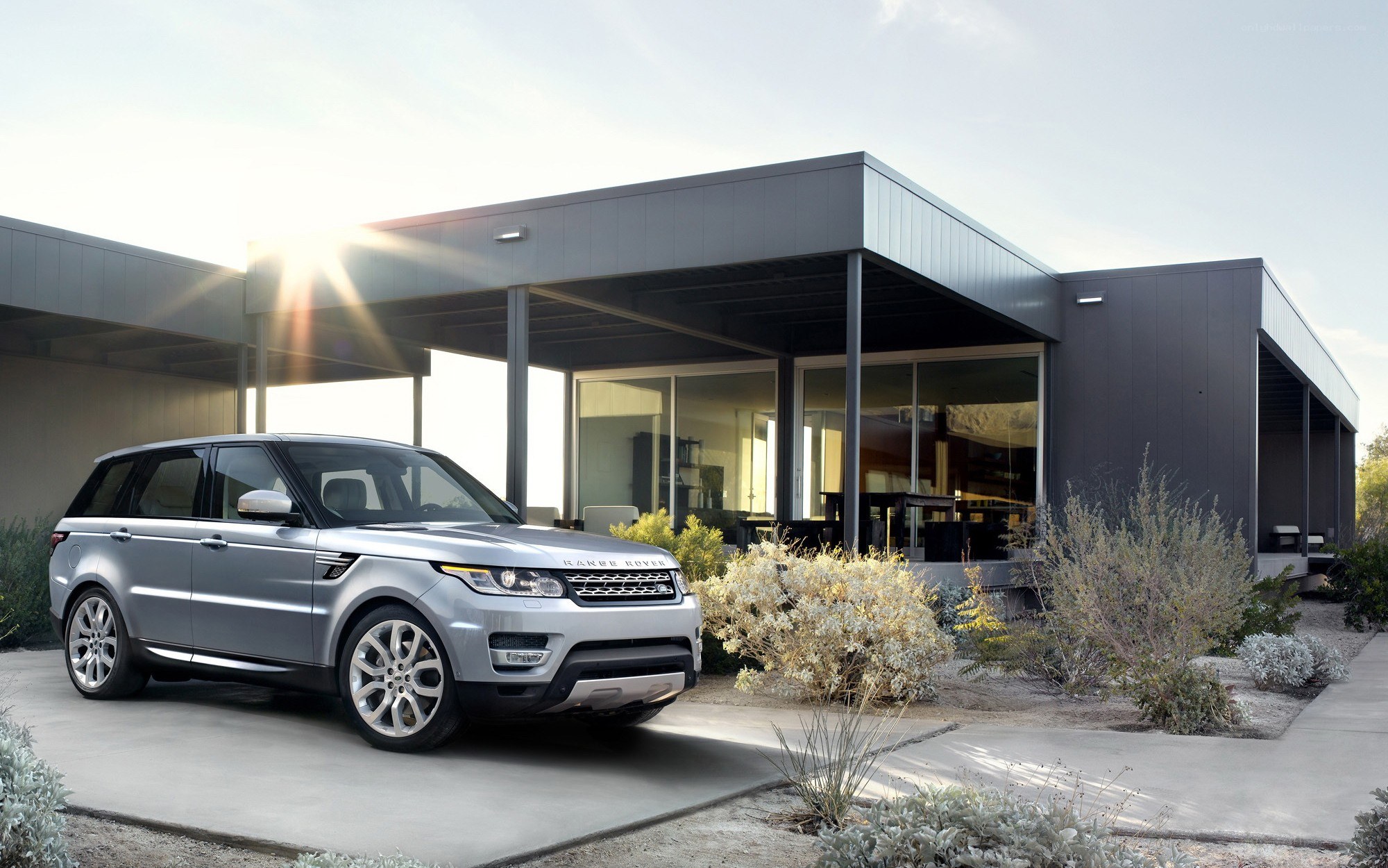 Silver Range Rover parked outside modern home