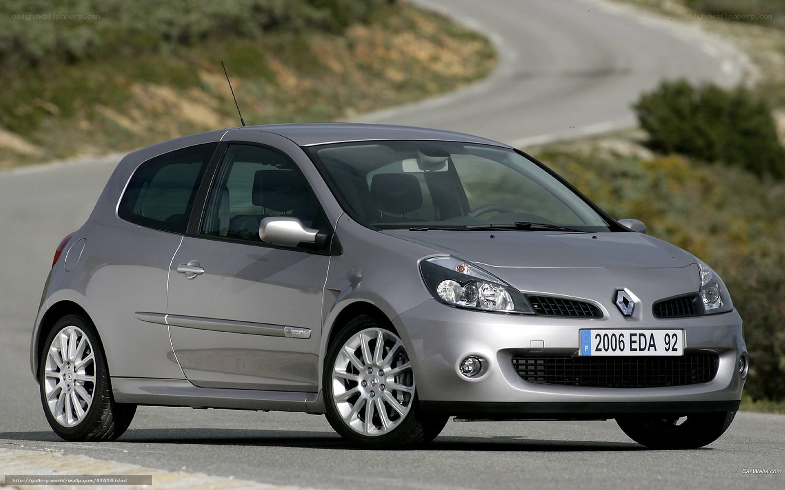 silver renault clio on winding road