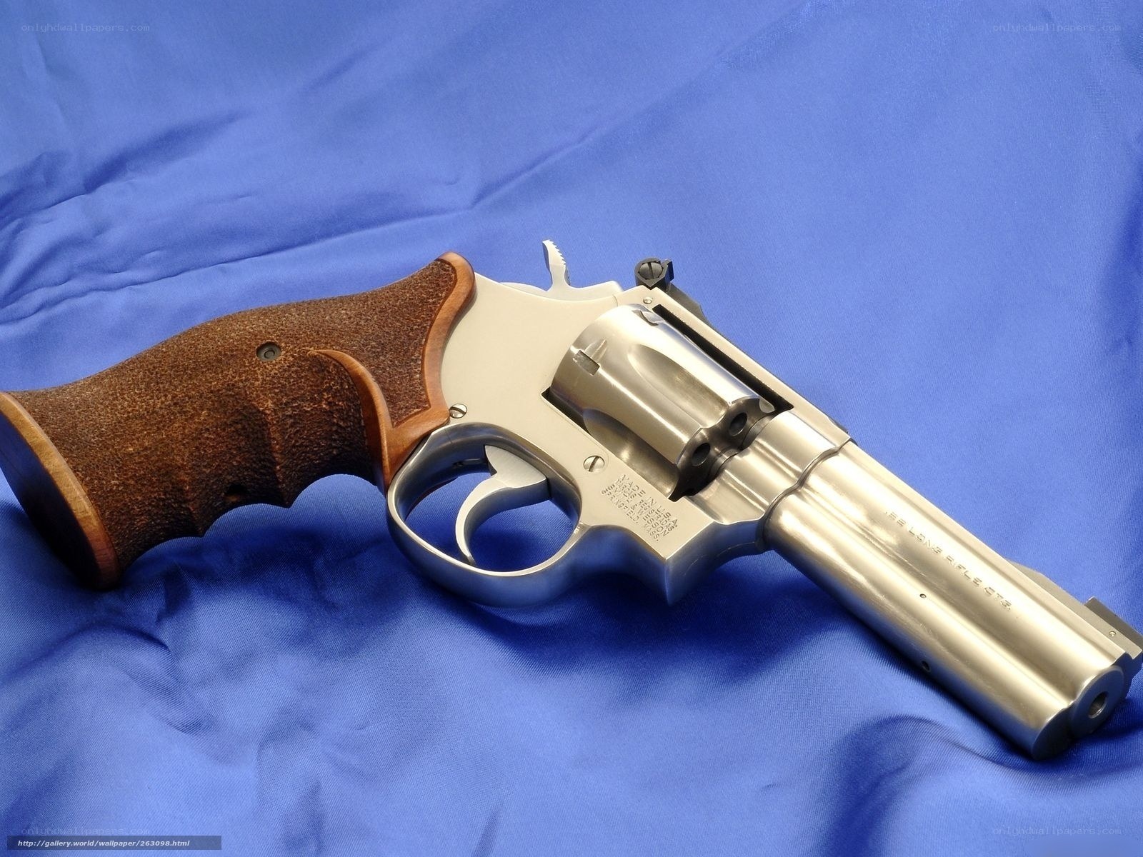 silver revolver on blue cloth